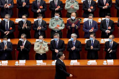 El presidente chino, Xi Jinping, pasa junto a funcionarios con máscaras faciales tras el brote de la enfermedad del coronavirus (COVID-19) cuando llega a la sesión de apertura de la Conferencia Consultiva Política del Pueblo Chino (CPPCC) en el Gran Salón del Pueblo en Beijing, China.