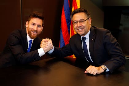Otros tiempos: Josep María Bartomeu, presidente de Barcelona, estrecha la mano de Lionel Messi. El argentino ya no quiere jugar en el equipo catalán.