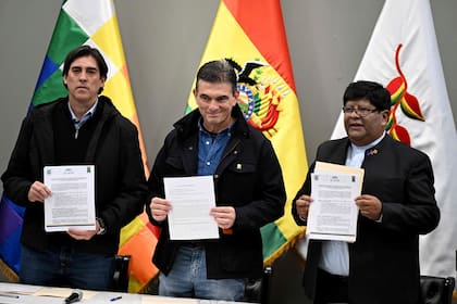 El presidente de Bolivia, Rodrigo Paz, el ministro de Obras Públicas, Mauricio Zamora Liebers, y el alcalde de El Alto, Eliser Roca, sostienen copias firmadas de un acuerdo en la Casa Grande del Pueblo, sede del palacio presidencial, en La Paz