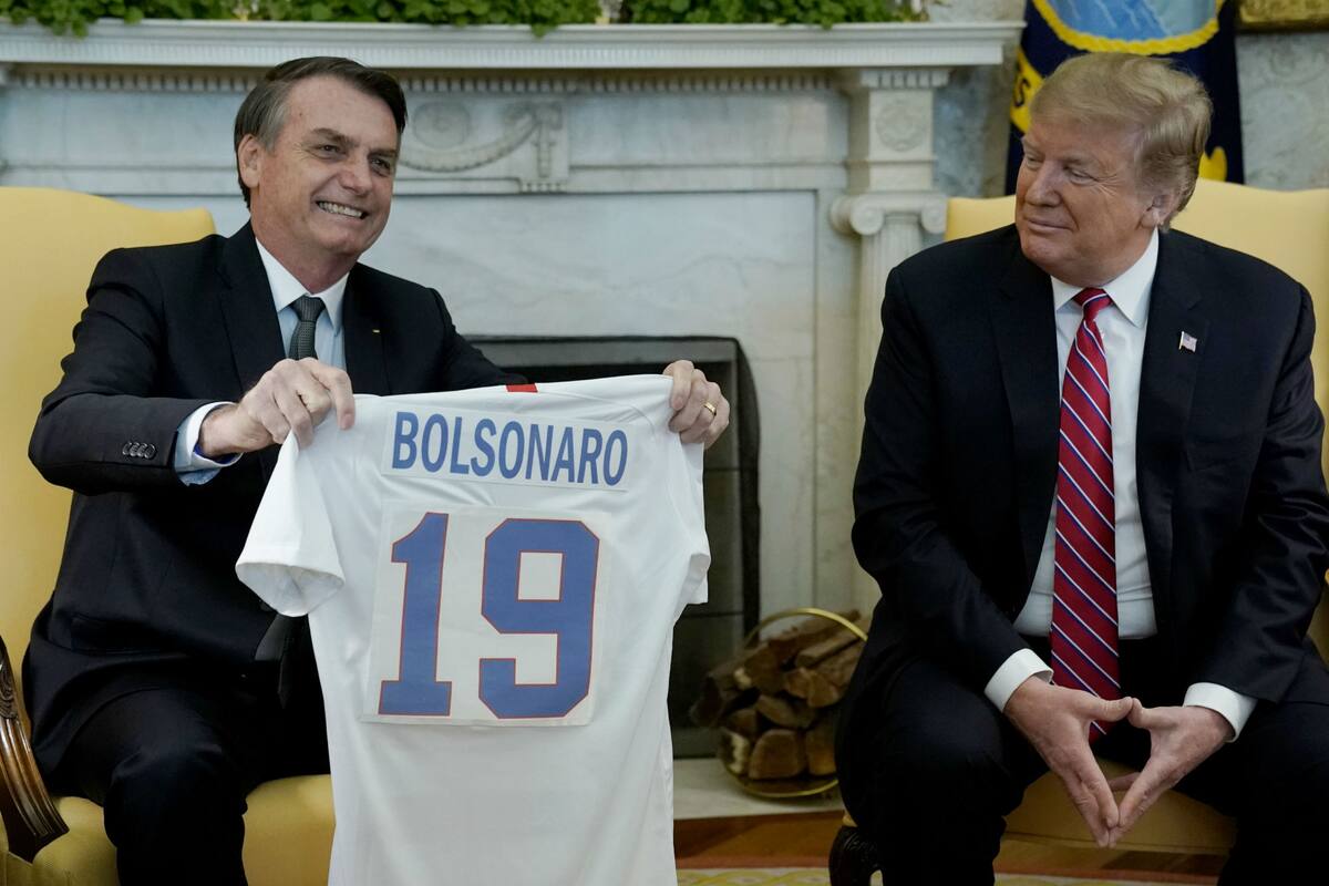 El presidente de Brasil, Jair Bolsonaro, recibe una camiseta de fútbol de los Estados Unidos del presidente Donald Trump, antes de una reunión en la Oficina Oval de la Casa Blanca