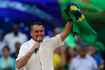 El presidente de Brasil, Jair Bolsonaro, sostiene una bandera brasileña durante un mitin para lanzar su candidatura a la reelección, en Río de Janeiro, Brasil, el domingo 24 de julio de 2022. (Foto AP/Bruna Prado)