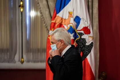 El presidente de Chile, Sebastián Piñera, se vuelve a poner la máscara en medio de la pandemia de COVID-19, luego de anunciar un estado de emergencia en las regiones sureñas de La Araucanía y Biobío, en el palacio presidencial de La Moneda en Santiago, Chile, el martes 12 de octubre de 2021. (AP Foto/Esteban Felix)