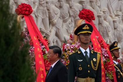 El presidente de China, Xi Jinping, pasa junto a coronas de flores después de presentar sus respetos ante el Monumento a los Héroes Populares, durante un acto para conmemorar el Día de los Mártires, en la plaza de Tiananmen, en Beijing, el 30 de septiembre de 2021. (AP Foto/Andy Wong)