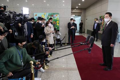 El presidente de Corea del Sur, Yoon Suk Yeol, a la derecha, habla con la prensa a su llegada a la oficina presidencial en Seúl, Corea del Sur, el martes 11 de octubre de 2022. (Ahn Jung-hwan/Yonhap via AP)