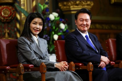 El presidente de Corea del Sur, Yoon Suk Yeol, se sienta con su esposa Kim Keon Hee. La pareja se encuentra en medio de un escándalo después de que un video filtrado mostrara a la primera dama recibiendo una cartera Dior