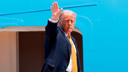El presidente de EE.UU., Donald Trump, saluda con la mano desde las escaleras del Air Force One mientras sube en la Base Conjunta Andrews, en Maryland