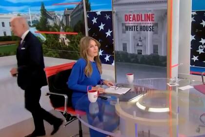 El presidente de EE.UU., Joe Biden, pasa detrás de la presentadora Nicolle Wallace al abandonar la entrevista antes del corte comercial