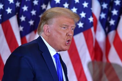 El presidente de Estados Unidos, Donald Trump, hace un gesto después de hablar durante la noche de las elecciones en el ala este de la Casa Blanca en Washington