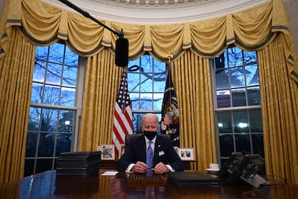 El presidente de Estados Unidos, Joe Biden, firma una serie de decretos en la Oficina Oval de la Casa Blanca en Washington, DC, después de prestar juramento en el Capitolio el 20 de enero de 2021