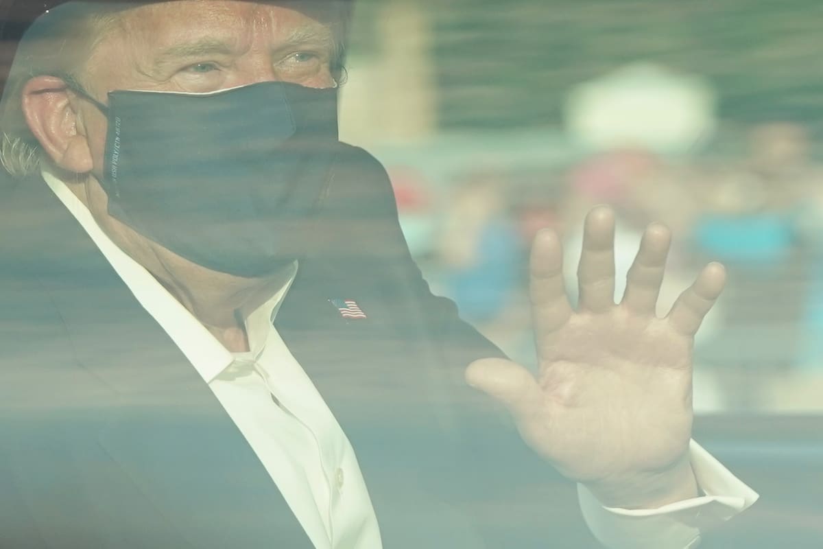 El presidente de Estados Unidos, Trump, saluda desde la parte trasera de un automóvil en una caravana fuera del Centro Médico Walter Reed en Bethesda, Maryland, el 4 de octubre de 2020