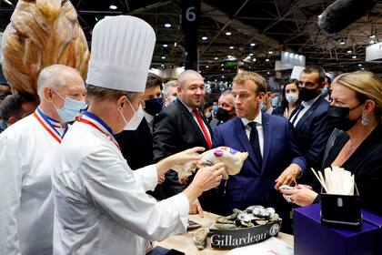 El presidente de Francia, Emmanuel Macron, prueba productos durante su visita al Salón Internacional de la Restauración, la Hostelería y la Alimentación (SIRHA) en Lyon, en el centro de Francia, el lunes 27 de septiembre de 2021.(Denis Balibouse/Pool via AP)
