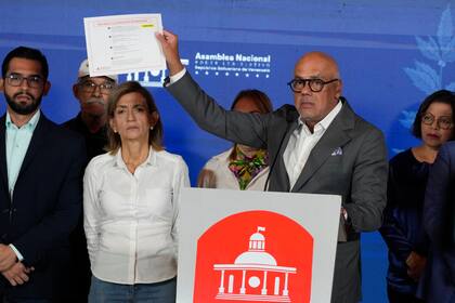 El presidente de la Asamblea Nacional venezolana Jorge Rodriguez muestra un documento según el cual la candidata presidencial opositora Maria Corina Machado ataca al gobierno, en Caracas, 25 de enero de 2024. (AP Foto/Ariana Cubillos)