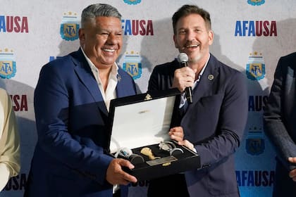 El presidente de la CONMEBOL Alejandro Domínguez (derecha) presenta un obsequio al presidente de la Asociación del Fútbol Argentino Claudio Tapia, el jueves 7 de diciembre de 2023, durante la apertura de la sede de la AFA en Miami. (AP Foto/Marta Lavandier)
