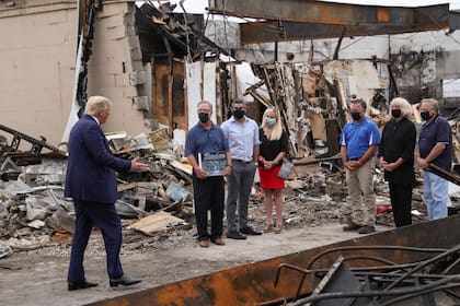 Trump, con empresarios locales mientras examina los daños en un negocio de Kenosha a raíz de las recientes protestas contra la brutalidad policial y la injusticia racial