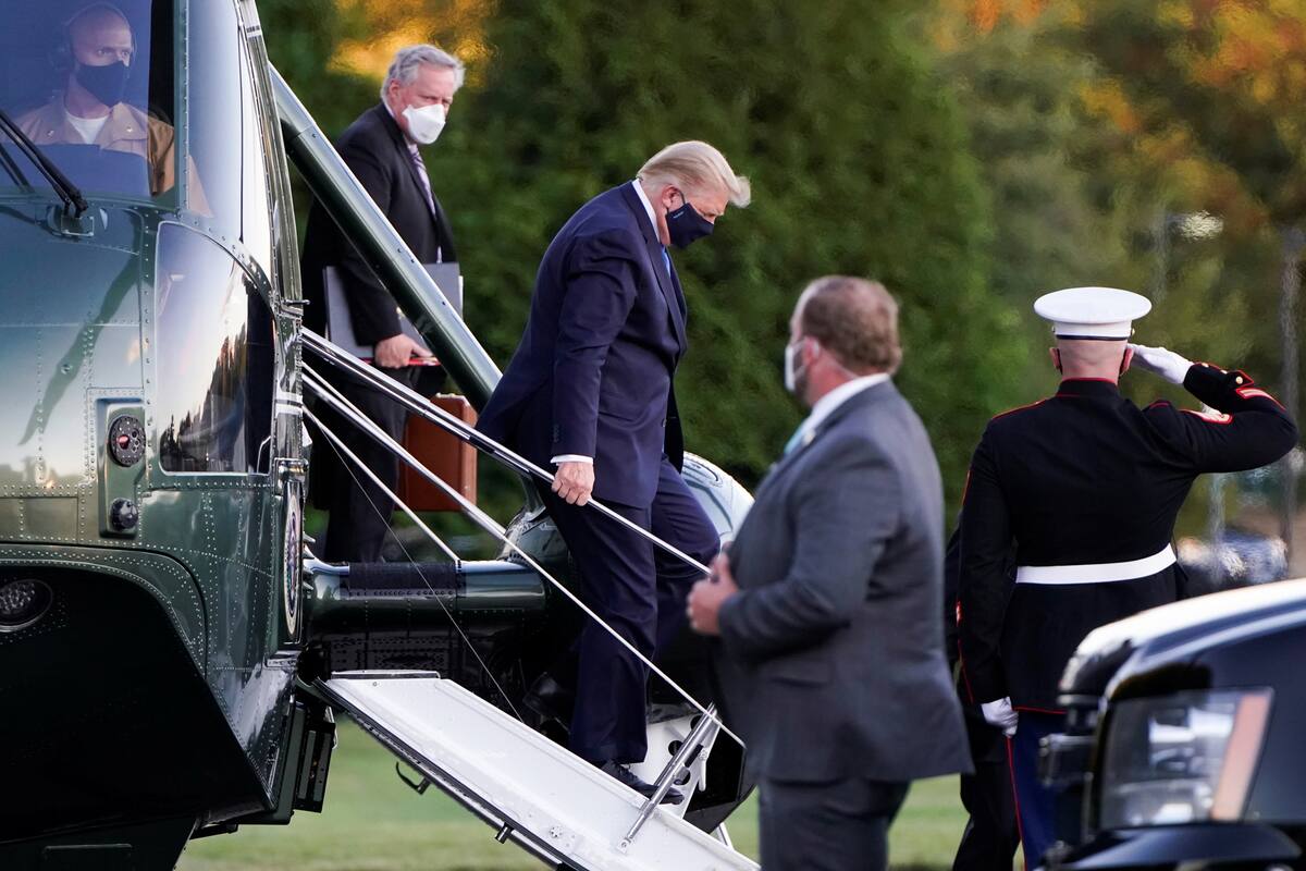 El presidente de los Estados Unidos, Donald Trump, desembarca del helicóptero Marine One seguido por el jefe de personal de la Casa Blanca, Mark Meadows, cuando llega al Centro Médico Militar Nacional Walter Reed después de que la Casa Blanca anunciara que "trabajará desde las oficinas presiden