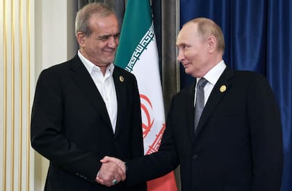 El presidente de Rusia, Vladimir Putin, estrecha la mano del presidente de Iran, Masoud Pezeshkian, durante la cumbre de la Organización de Cooperación de Shanghái en Tianjin