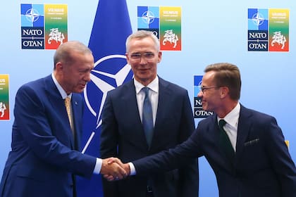 El presidente de Turquía, Recep Tayyip Erdogan, a la izquierda, le da la mano al primer ministro de Suecia, Ulf Kristersson, a la derecha, mientras el secretario general de la OTAN, Jens Stoltenberg, observa antes de una reunión previa a la cumbre de la OTAN en Vilna, Lituania, el 10 de julio de 2023. (Yves Herman, pool vía AP)