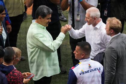 El presidente de Venezuela Nicolás Maduro choca los puños con el Ministro de Deportes de Rusia Oleg Matytsin durante la ceremonia de inauguración de los Juegos del Alba en La Guair, Venezuela el viernes 21 de abril del 2023. (AP Foto/Ariana Cubillos)