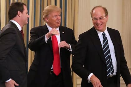 El presidente de Walmart, Donald Trump y Larry Fink en un foro en febrero de este año