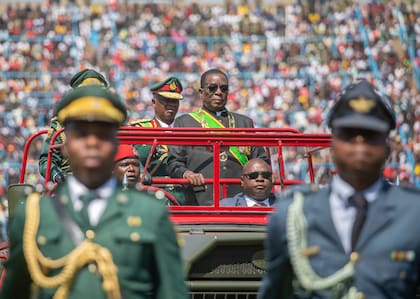 El presidente de Zimbabue, Emmerson Mnangagwa, centro, inspecciona una guardia de honor desde un camión militar en la conmemoración del 44to. Día de las Fuerzas de Defensa de Zimbabue en el estadio Rufaro, en Harare, el martes 13 de agosto de 2024. (AP Foto/Aaron Ufumeli)