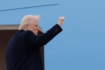 El presidente Donald Trump alza un puño antes de ingresar al Air Force One el viernes 14 de marzo de 2025, en la Base Conjunta Andrews, Maryland