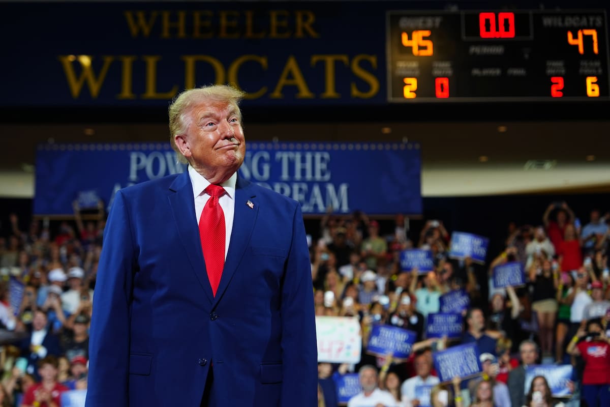 El presidente Donald Trump aparece en el escenario de la escuela secundaria Wheeler High School, el