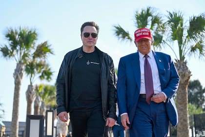 El presidente Donald Trump, camina junto a Elon Musk uno de los impulsores de la medida para dejar de imprimir las monedas de un centavo. (Brandon Bell/Pool vía AP)