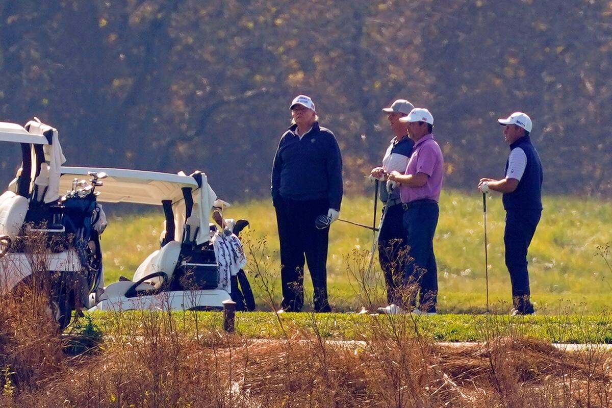 El presidente Donald Trump, de pie en el centro, mientras participa en una ronda de golf en el Trump National Golf Course el sábado 7