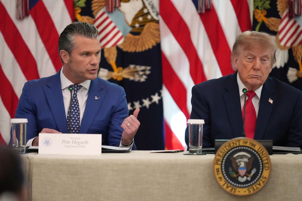 El presidente Donald Trump escucha mientras el secretario de Defensa Pete Hegseth habla en una mesa