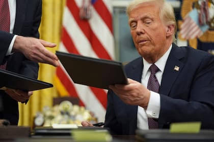El presidente Donald Trump firma órdenes ejecutivas en la Oficina Oval de la Casa Blanca, el lunes 20 de enero de 2025, en Washington.