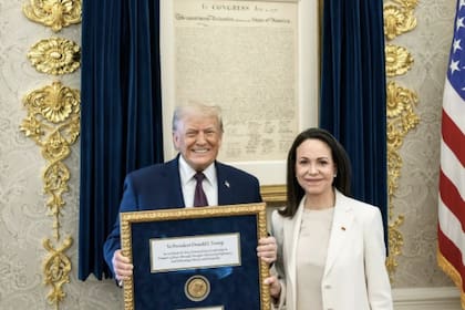 El presidente Donald Trump junto a María Corina Machado, en la Casa Blanca, con el presente que le llevó la líder opositora venezolana.
