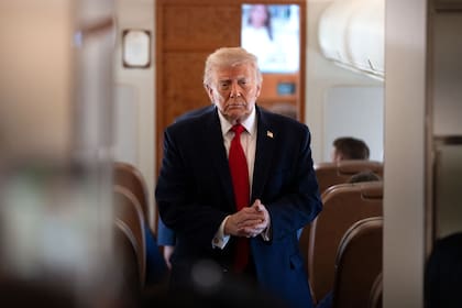 El presidente Donald Trump llega para hablar con periodistas a bordo del Air Force One, en ruta desde la base Andrews, Maryland, a Eau Claire, Wisconsin.
