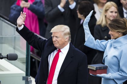 El presidente Donald Trump y la primera dama Melania Trump saludan a la multitud durante la 58.ª inauguración presidencial de Estados Unidos después de que Trump fuera juramentado como el 45.º presidente de los Estados Unidos de América en Washington, EE. UU., el 20 de enero de 2017.