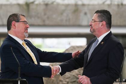 El presidente electo de Guatemala, Bernardo Arévalo, a la izquierda, y el mandatario de Costa Rica, Rodrigo Chaves, estrechan manos en una ceremonia de bienvenida en San José, Costa Rica, el miércoles 13 de diciembre de 2023. Chaves recibió el miércoles a Arévalo, quien enfrenta en su país una arremetida de la fiscalía contra el proceso electoral del que resultó ganador, a un mes de la toma de posesión del cargo de presidente de Guatemala. (AP Foto/Carlos González)
