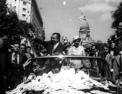 El presidente electo, Raúl Alfonsín, saluda a la multitud el 10 de diciembre de 1983 en Buenos Aires durante su desfile de investidura. FOTO AFP