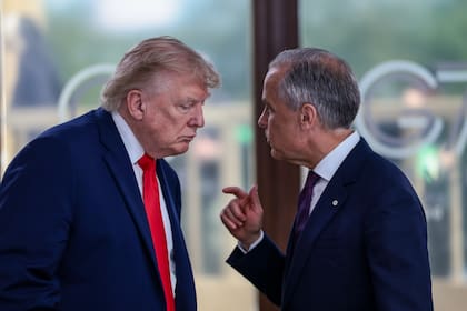 El presidente estadounidense Donald Trump conversa con el primer ministro canadiense Mark Carney, a la derecha, durante un almuerzo de trabajo con líderes del G7 y de Oriente Medio