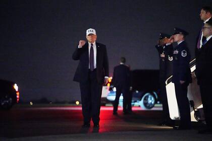 El presidente estadounidense Donald Trump levanta el puño tras descender del Air Force One en el Aeropuerto Internacional de Palm Beach, en West Palm Beach, Florida
