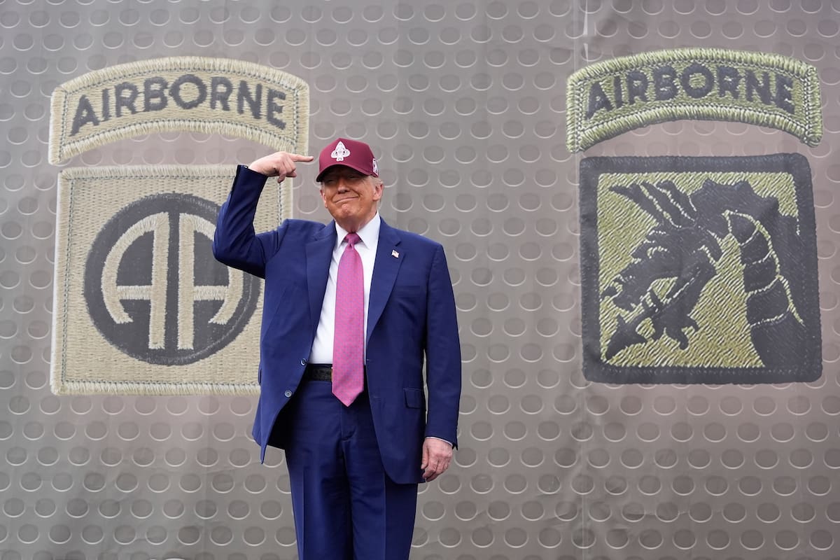 El presidente estadounidense Donald Trump señala una gorra del Ejército durante un evento en Fort Bragg, Carolina del Norte, el martes 10 de junio de 2025