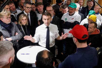 El presidente francés, Emmanuel Macron, hace gestos durante una discusión con agricultores franceses miembros de sindicatos agrícolas en el centro de exposiciones Porte de Versailles, el día de la inauguración de la 60ª Feria Internacional de Agricultura (Salon de l'Agriculture), en París, el 24 de febrero de 2024