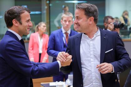 El presidente francés Emmanuel Macron (izq) saluda al primer ministro de Luxemburgo Xavier Bettel el 24 de junio del 2022 durante una cumbre de la Unión Europea en Bruselas. (AP Photo/Olivier Matthys)