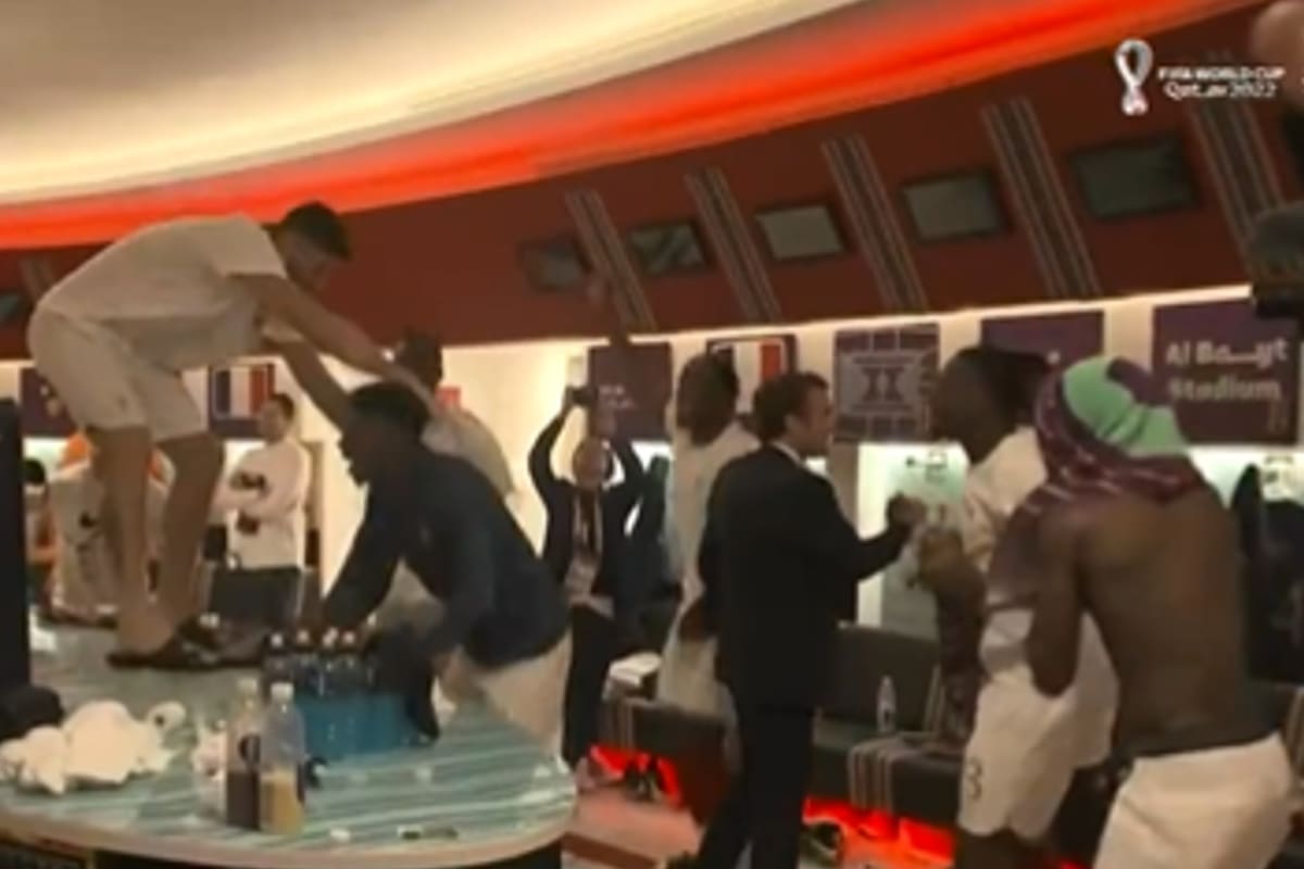 El presidente francés Emmanuel Macron saluda a los jugadores del seleccionado de su país en medio de la celebración en los vestuarios, con Giroud subido a una mesa.