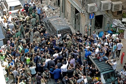 El presidente francés, Emmanuel Macron, saluda a la gente durante una visita al barrio de Gemmayzeh, que ha sufrido grandes daños debido a una explosión masiva en Beirut