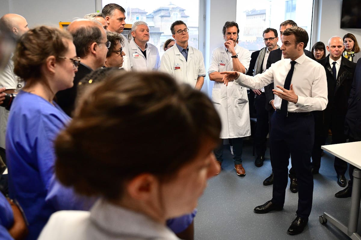 El presidente francés, Emmanuel Macron, se reúne con el personal médico mientras visita el hospital Pitie-Salpetriere en París el 27 de febrero de 2020, donde la primera víctima francesa de COVID-19 falleció el día anterior.