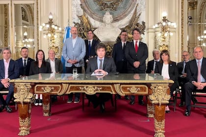 El presidente Javier Milei junto a sus ministros y otros miembros de su Gobierno al anunciar el DNU