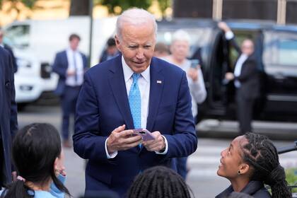 El presidente Joe Biden habla con unos niños tras salir de BMORE LICKS, un negocio de helados hechos en casa, el martes 29 de octubre de 2024, en Baltimore. (AP Foto/Mark Schiefelbein)