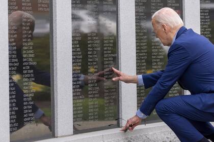 El presidente Joe Biden toca el nombre de su tío Ambrose J. Finnegan, Jr., en una pared de un monumento a los caídos en Scranton, el miércoles 17 de abril de 2024, en Scranton, Pensilvania