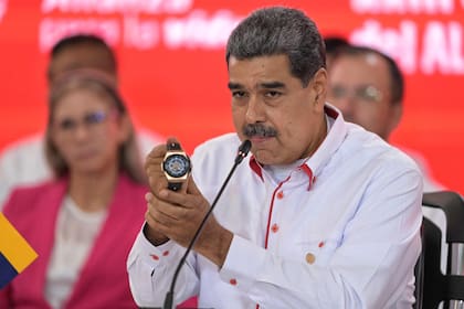 El presidente Nicolás Maduro muestra un reloj que le regaló Diego Maradona durante una cumbre en Caracas. (JUAN BARRETO / AFP)