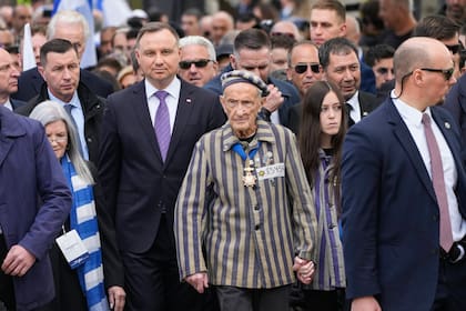 El presidente polaco Andrzej Duda, centro izquierda, y el sobreviviente estadounidense de Auschwitz, Edward Mosberg, centro derecha, asisten a la recordación anual del Holcausto en Oswiecim, Polonia, jueves 28 de abril de 2022. (AP Foto/Czarek Sokolowski)