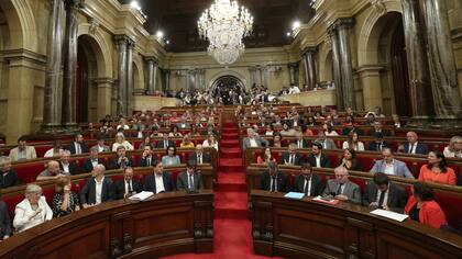 El presidente regional de Cataluña, Carles Puigdemont (centro, primera fila), en una sesión del Parlamento regional catalán en Barcelona, España