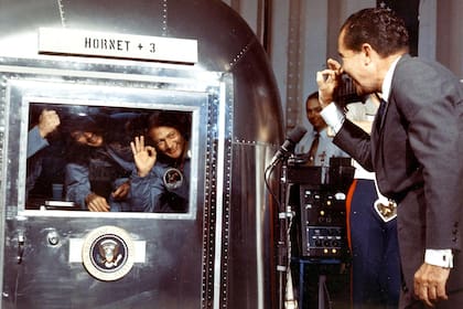El presidente Richard Nixon saluda a los astronautas Neil A. Armstrong, Michael Collins y Edwin E. Aldrin, tras su regreso a la Tierra, en la unidad de cuarentena luego de aterrizar de su viaje a la Luna, el 24 de julio de 1969